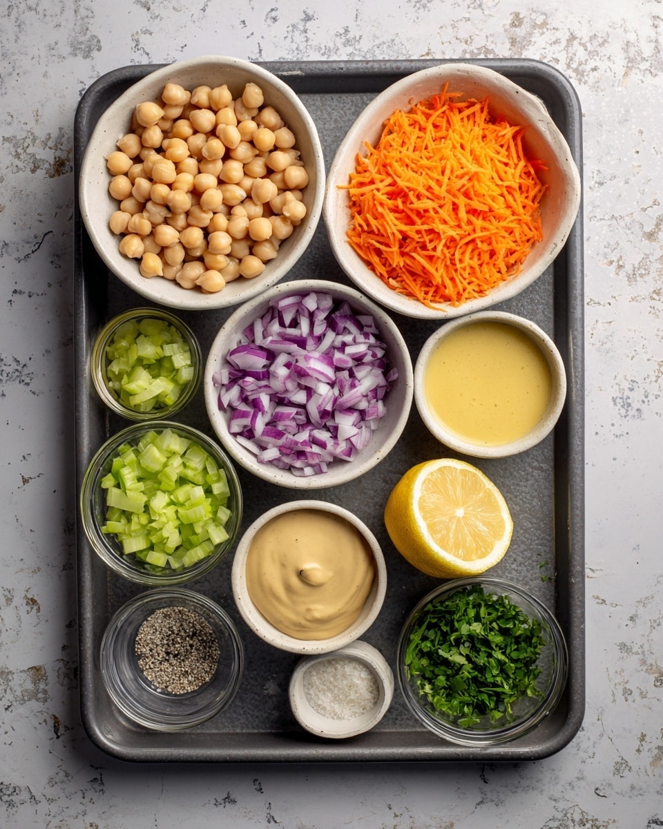 The image shows a baking tray on a white marbled surface with nine small white bowls and one half lemon placed on it. The top left bowl is filled with pale beige chickpeas, while to its right is a bowl with bright orange shredded carrots. Below the carrots, a bowl contains light beige tahini. Next to tahini is a bowl with creamy yellow dijon mustard. In the bottom right corner, a bowl holds green chopped cilantro. Below the cilantro is a tiny bowl with white and black salt and pepper mixed. Near the bottom center, a bowl has chopped purple and white red onion. Above the onion is a half lemon showing its bright yellow interior. To the left of the lemon, a clear bowl contains light green chopped celery, and to the right of celery, a tiny bowl has minced white garlic. All bowls are neatly arranged on a dark gray baking tray. photo taken with an iphone --ar 4:5 --v 7