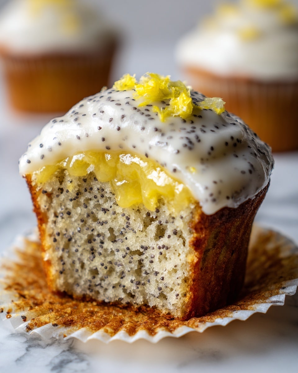 A close-up image of a lemon poppy seed cupcake with three visible layers: the bottom layer is a light yellow cake with black poppy seeds mixed in, the middle layer is a shiny, glossy lemon glaze, and the top layer is a thick swirl of creamy white frosting sprinkled with black poppy seeds. On top of the frosting sits small curls of bright yellow lemon zest. The cupcake is partially wrapped in a crinkled paper liner, all placed on a white marbled surface with soft light in the background. photo taken with an iphone --ar 4:5 --v 7