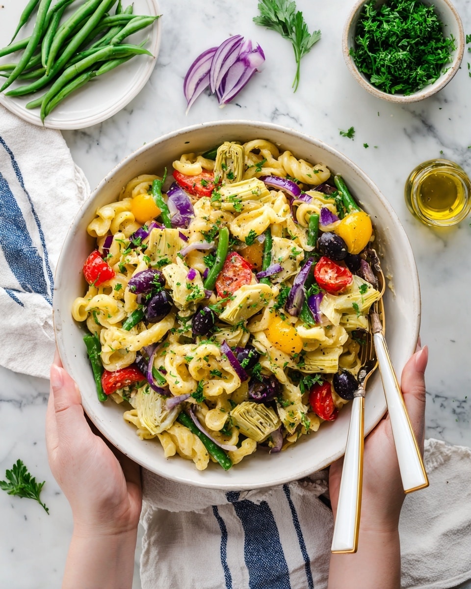 A large white bowl filled with a colorful pasta salad featuring twisted, off-white pasta strands mixed with halved cherry tomatoes in red and yellow, quartered artichoke hearts, and dark black olives scattered throughout. Thin slices of red onion and chopped green herbs are mixed in, adding fresh green touches. Two forks are held by a woman's hand at the bottom edges of the bowl, one on each side, ready to serve. The bowl sits on a white marbled surface with a white and blue cloth underneath, a small white plate of green beans and a white bowl of thinly sliced red onions nearby, along with fresh green herbs and a glass bottle of olive oil in the top left corner. photo taken with an iphone --ar 4:5 --v 7