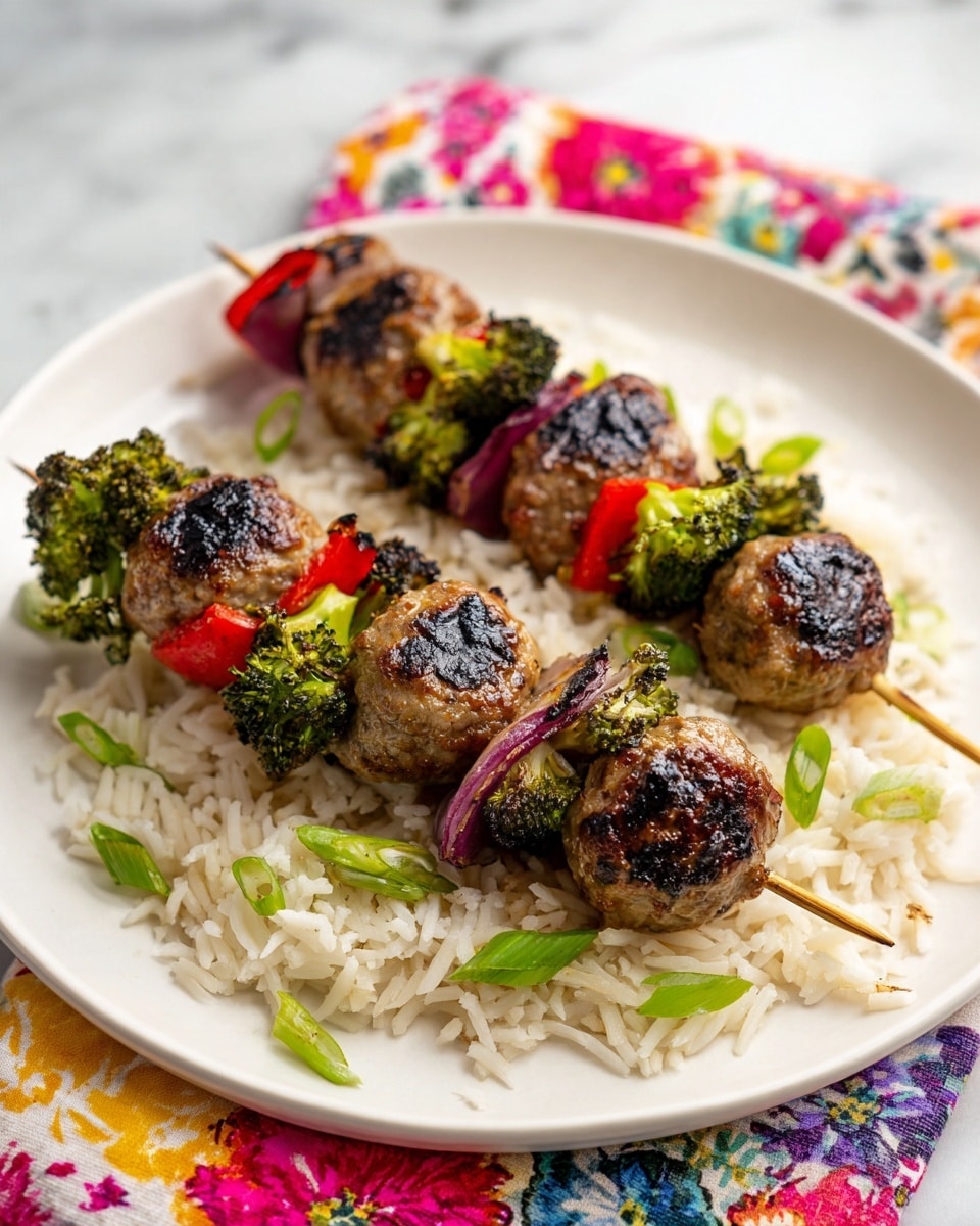 Two skewers lie on a bed of white rice on a white plate. Each skewer has four layers of grilled meatballs that are dark brown with a shiny glaze. Between the meatballs are grilled vegetables: bright green broccoli florets, red bell pepper pieces with charred spots, and light purple onion slices also grilled with some dark marks. The dish is topped with small green onion rings scattered over the meatballs and rice. The plate rests on a colorful floral tablecloth with various pastel colors. photo taken with an iphone --ar 4:5 --v 7
